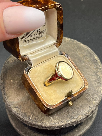 A yellow gold plain oval signet ring, in a ring box