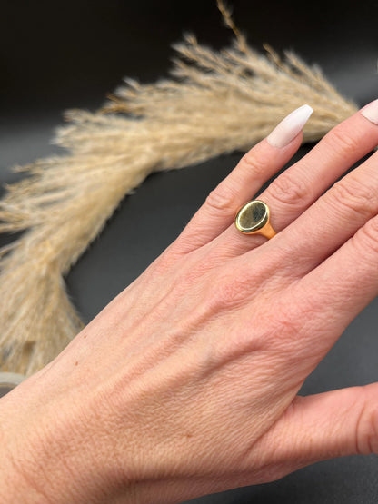 A yellow gold plain oval signet ring, modelled on a hand