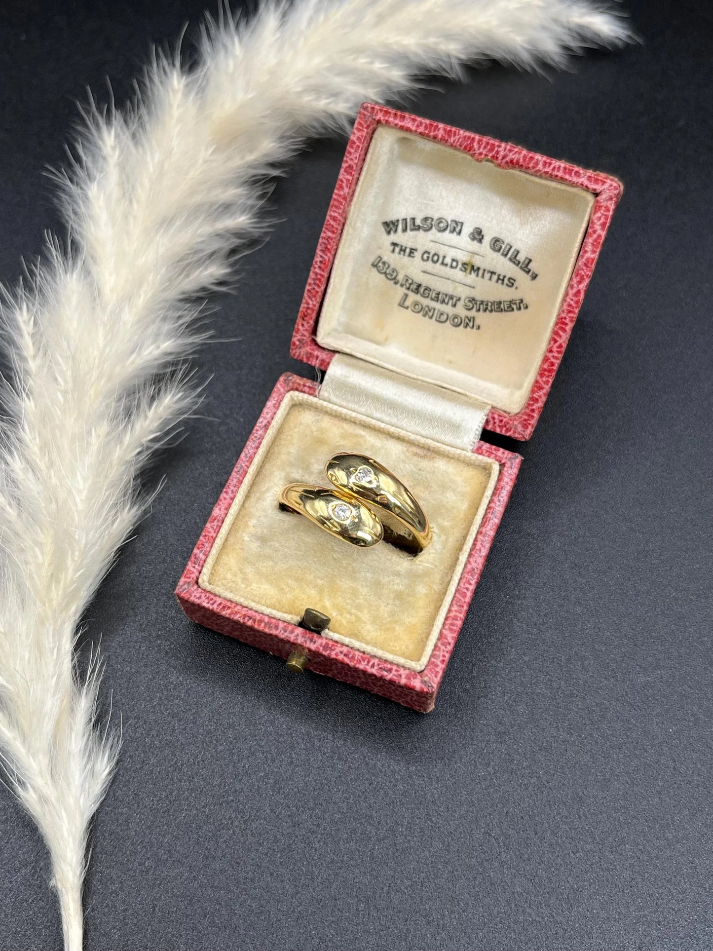 A yellow gold double headed snake ring with diamonds, in an antique ring box