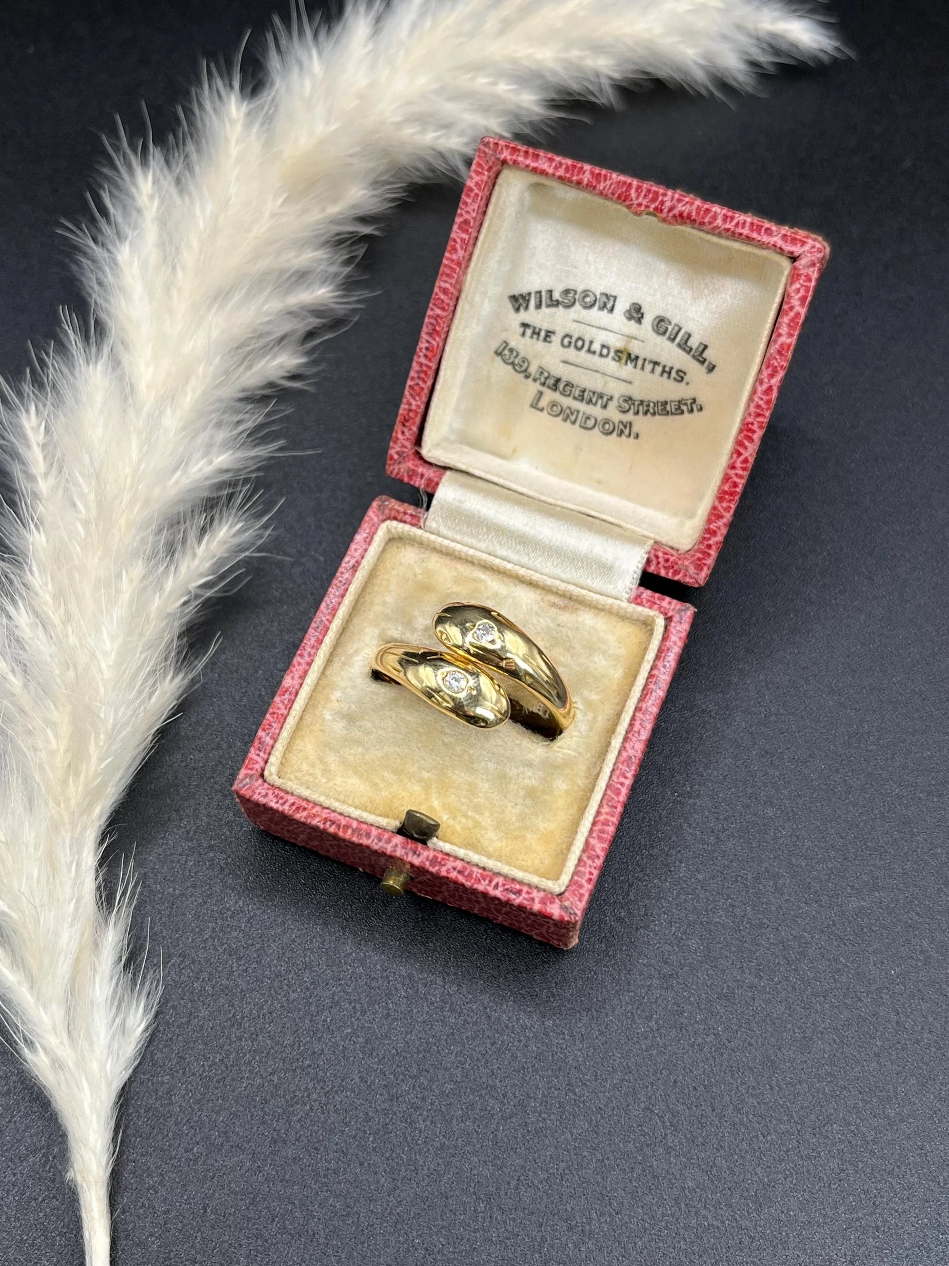 A yellow gold double headed snake ring with diamonds, in an antique ring box