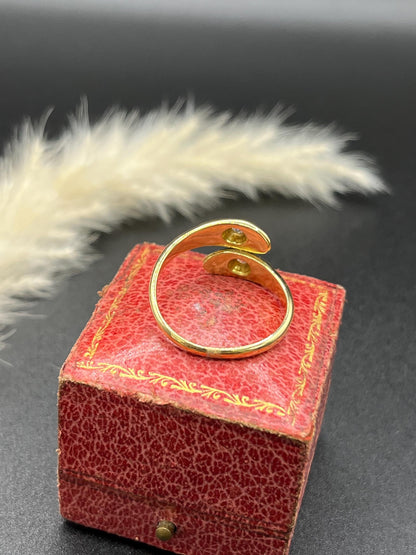 A yellow gold double headed snake ring with diamonds
