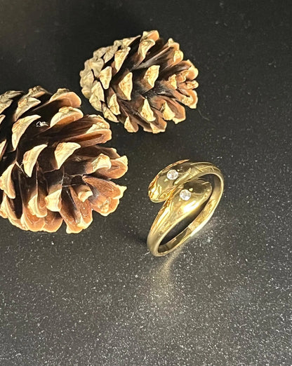 A yellow gold double headed snake ring with diamonds