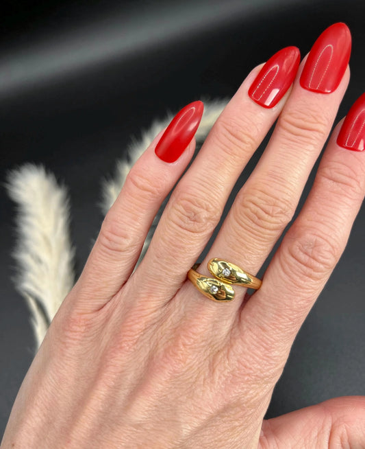 A yellow gold double headed snake ring with diamonds, modelled on a hand
