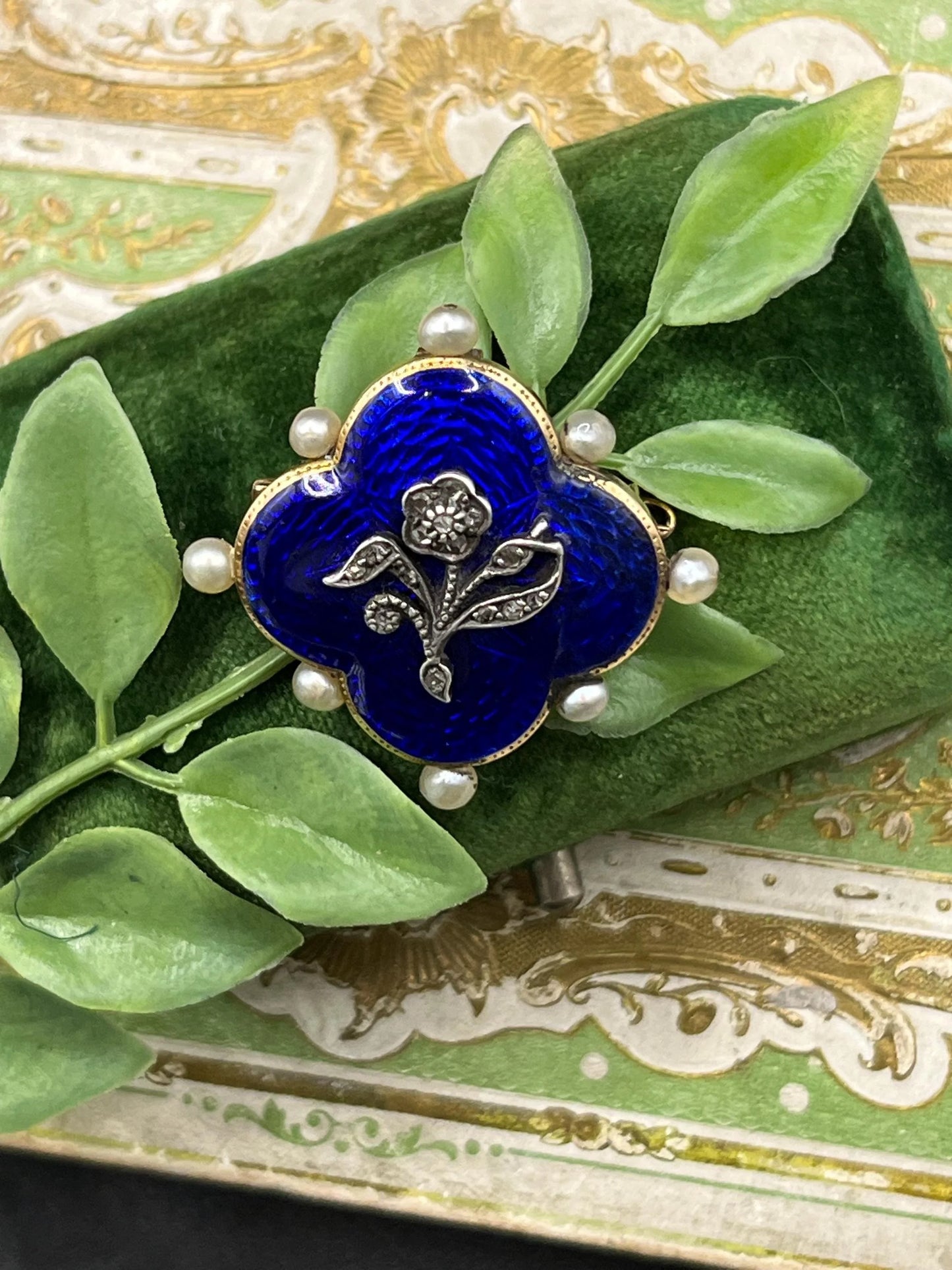 A diamond flower, blue enamel and pearl brooch in yellow gold
