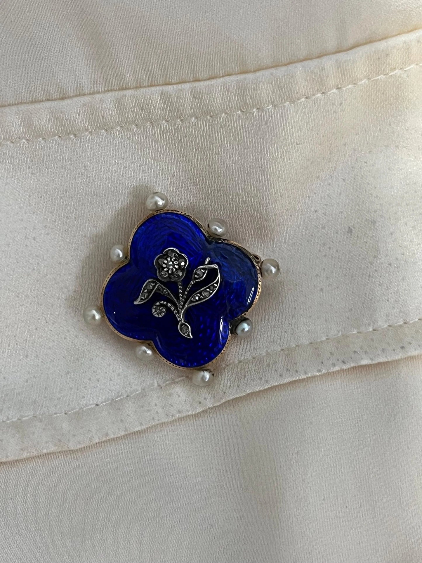 A diamond flower, blue enamel and pearl brooch in yellow gold