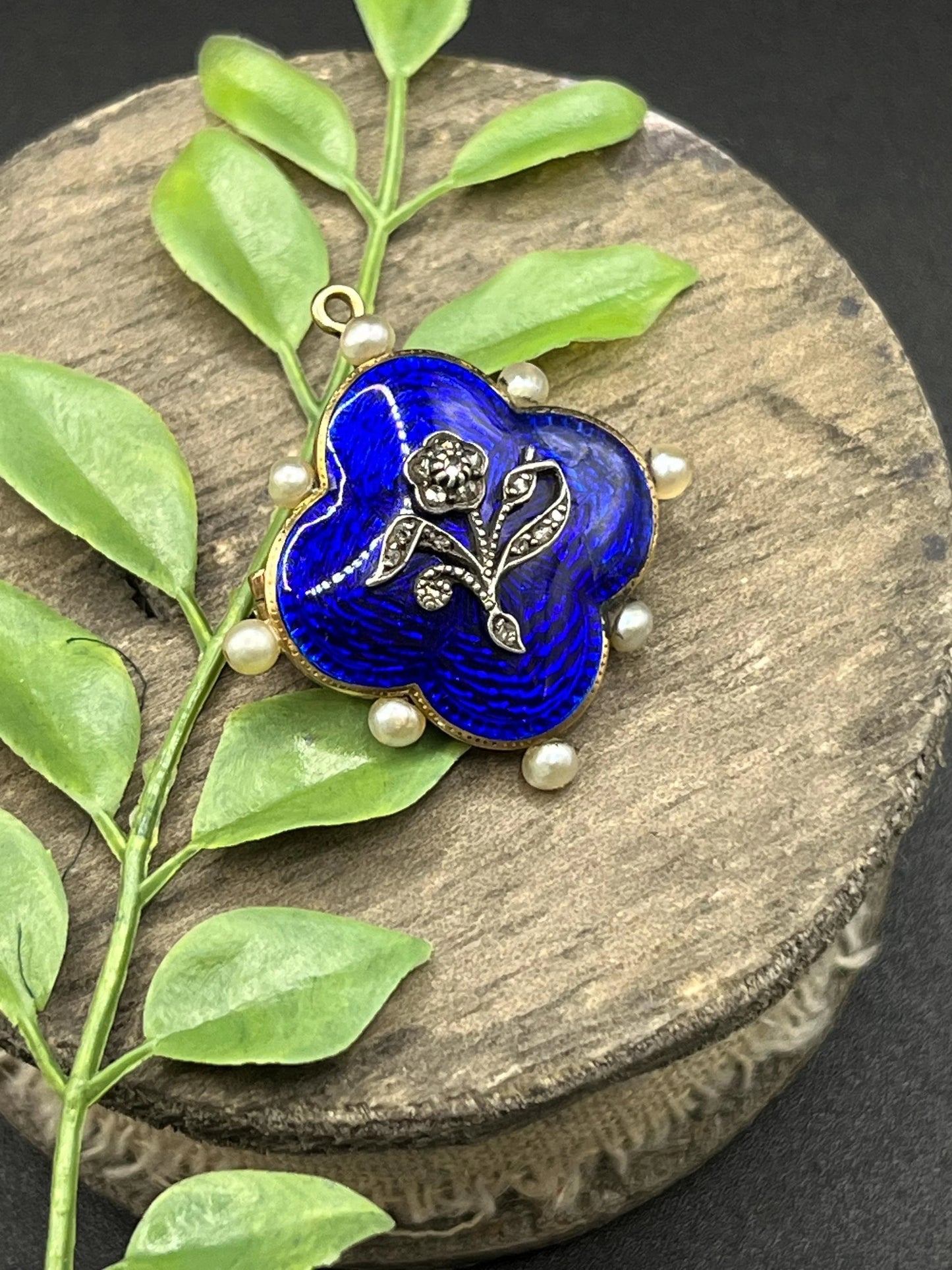 A diamond flower, blue enamel and pearl brooch in yellow gold