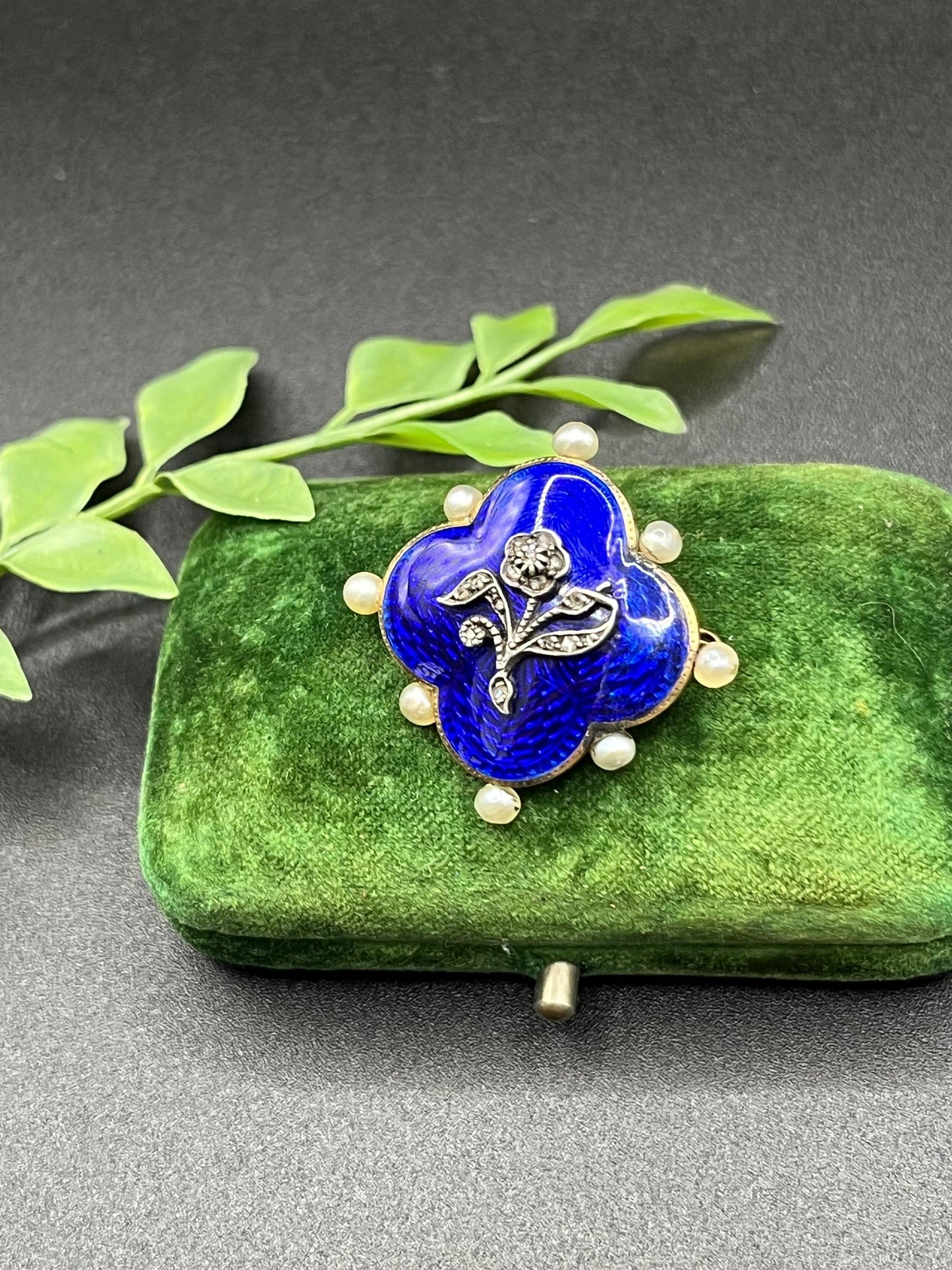 A diamond flower, blue enamel and pearl brooch in yellow gold