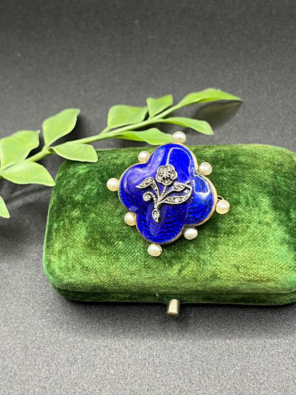 A diamond flower, blue enamel and pearl brooch in yellow gold