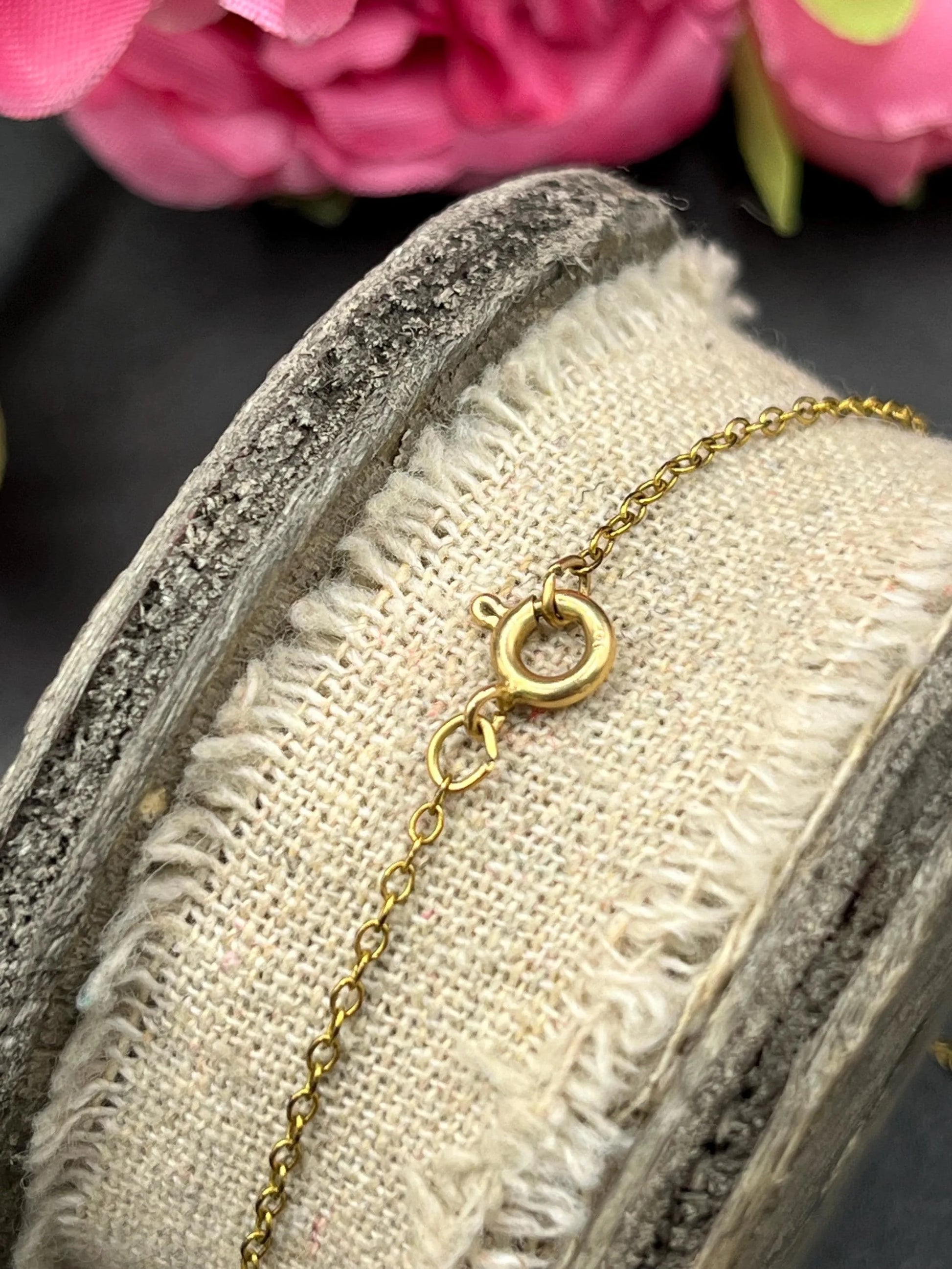Close-up of  a yellow gold chain and bolt ring clasp