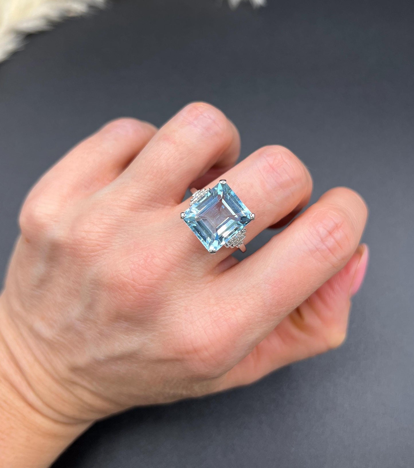 A large aquamarine and diamond dress ring in platinum, modelled on a hand