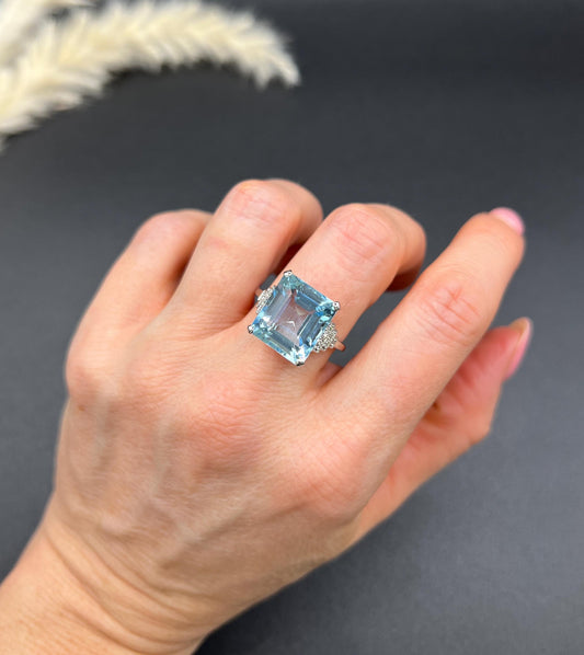 A large aquamarine and diamond dress ring in platinum, modelled on a hand