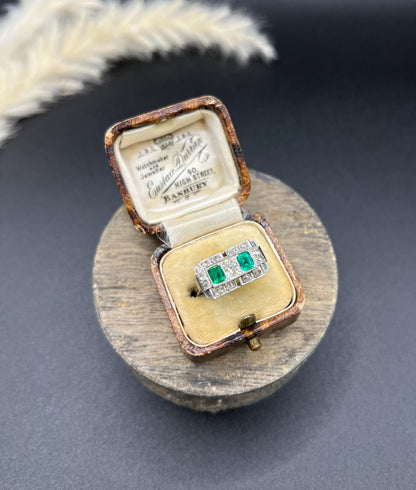 An emerald and old cut diamond rectangular ring in platinum, in an antique ring box