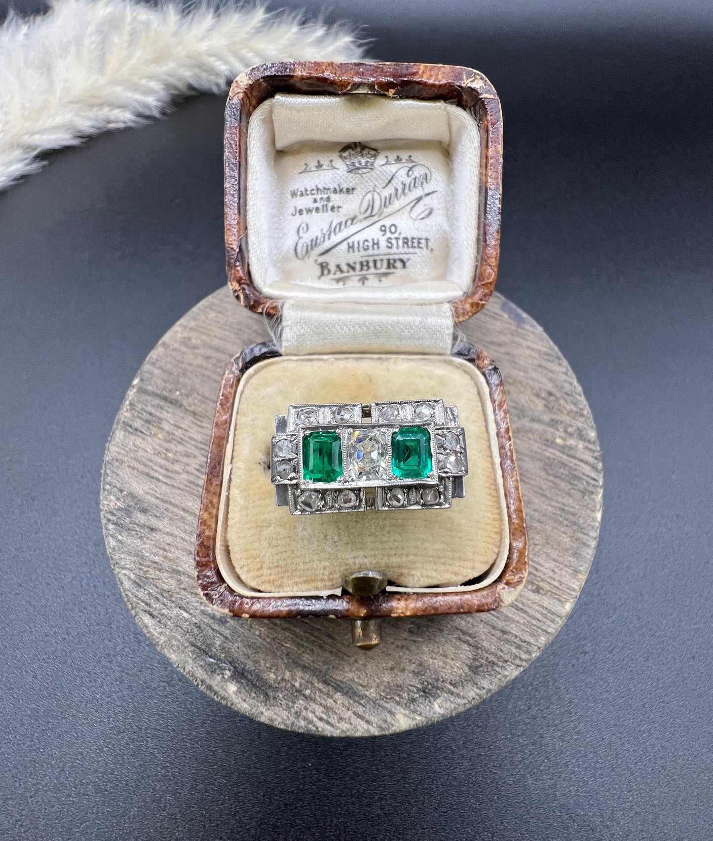 An emerald and old cut diamond rectangular ring in platinum, in an antique ring box