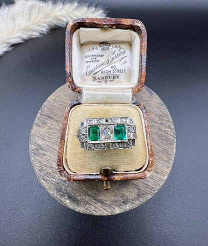 An emerald and old cut diamond rectangular ring in platinum, in an antique ring box