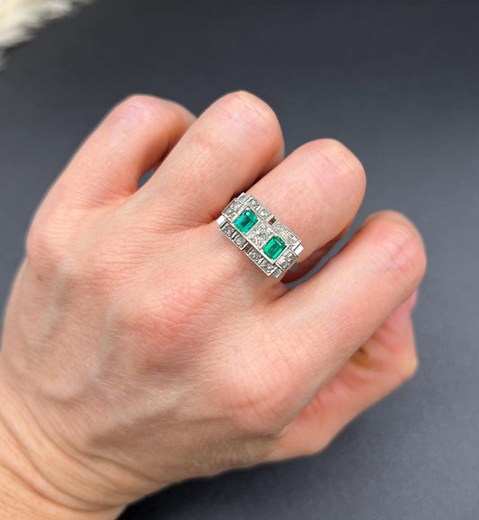 An emerald and old cut diamond rectangular ring in platinum, modelled on a hand
