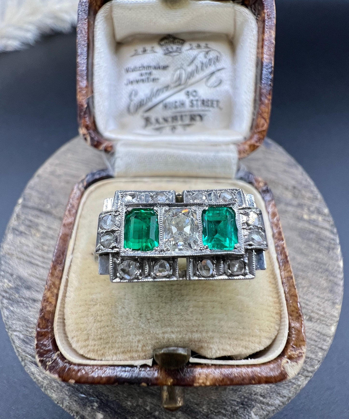 An emerald and old cut diamond rectangular ring in platinum, in a ring box