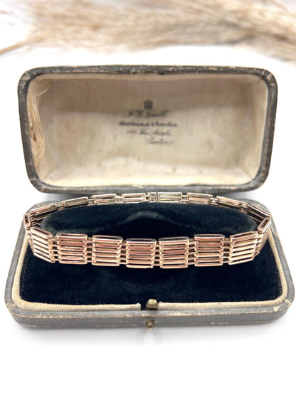 A yellow-rose gold gate style bracelet, in a box