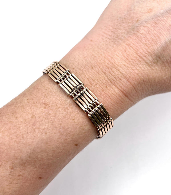 A yellow-rose gold gate style bracelet, modelled on a wrist