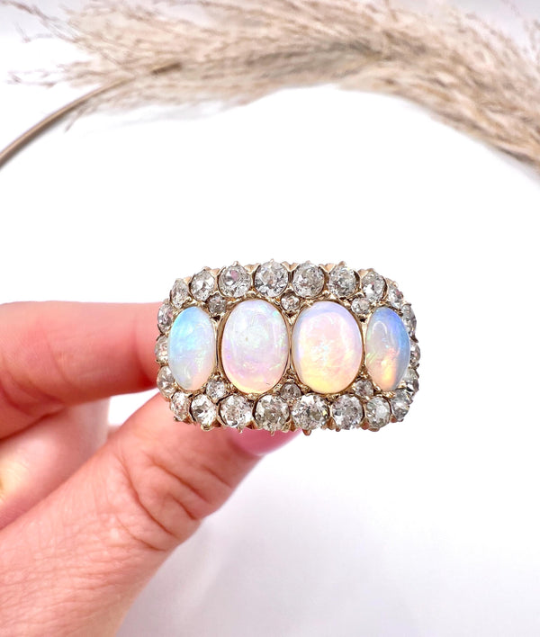 An antique oval opal and old cut diamond cluster row ring in yellow gold