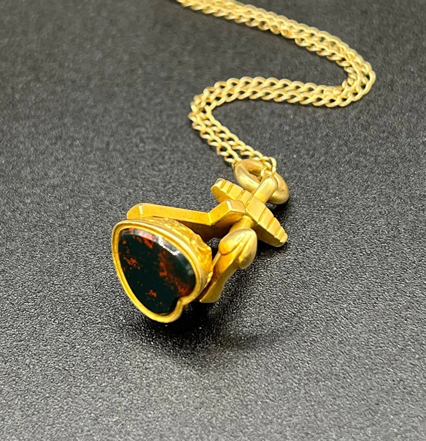 A yellow gold faith, hope and charity fob, with a heart-shaped bloodstone base, on a gold chain
