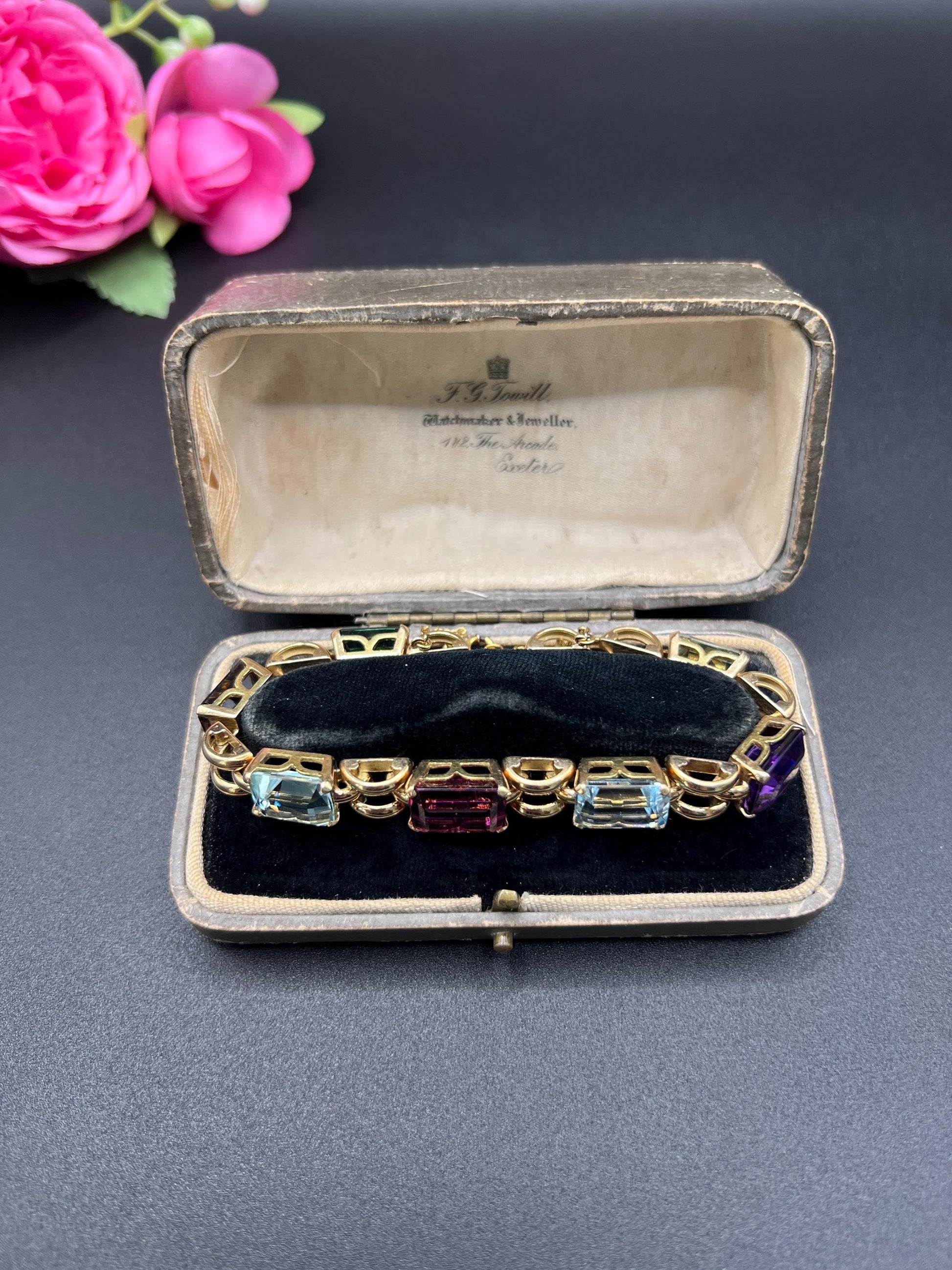 An emerald cut multi-gemstone bracelet in yellow gold, in a box