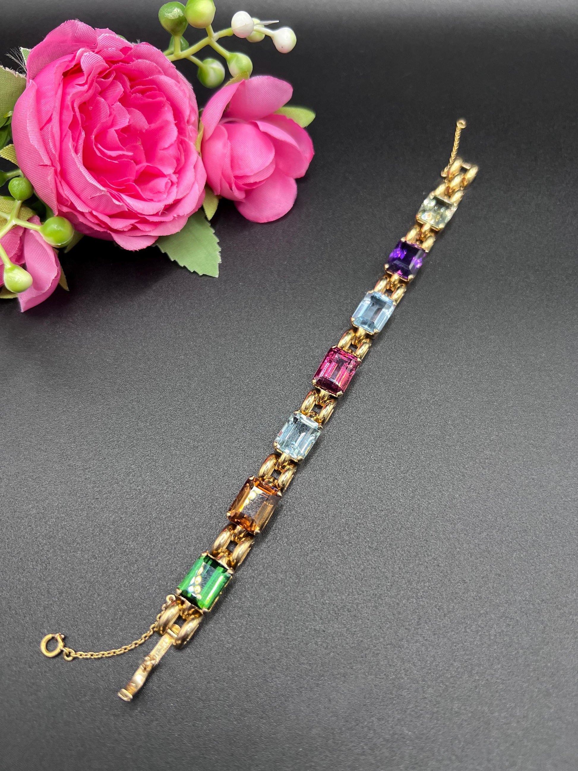 An emerald cut multi-gemstone bracelet in yellow gold
