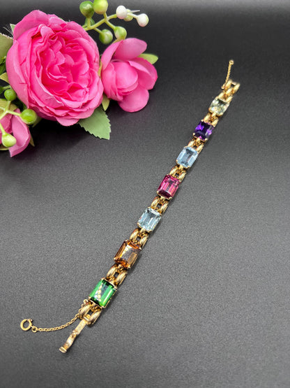 An emerald cut multi-gemstone bracelet in yellow gold
