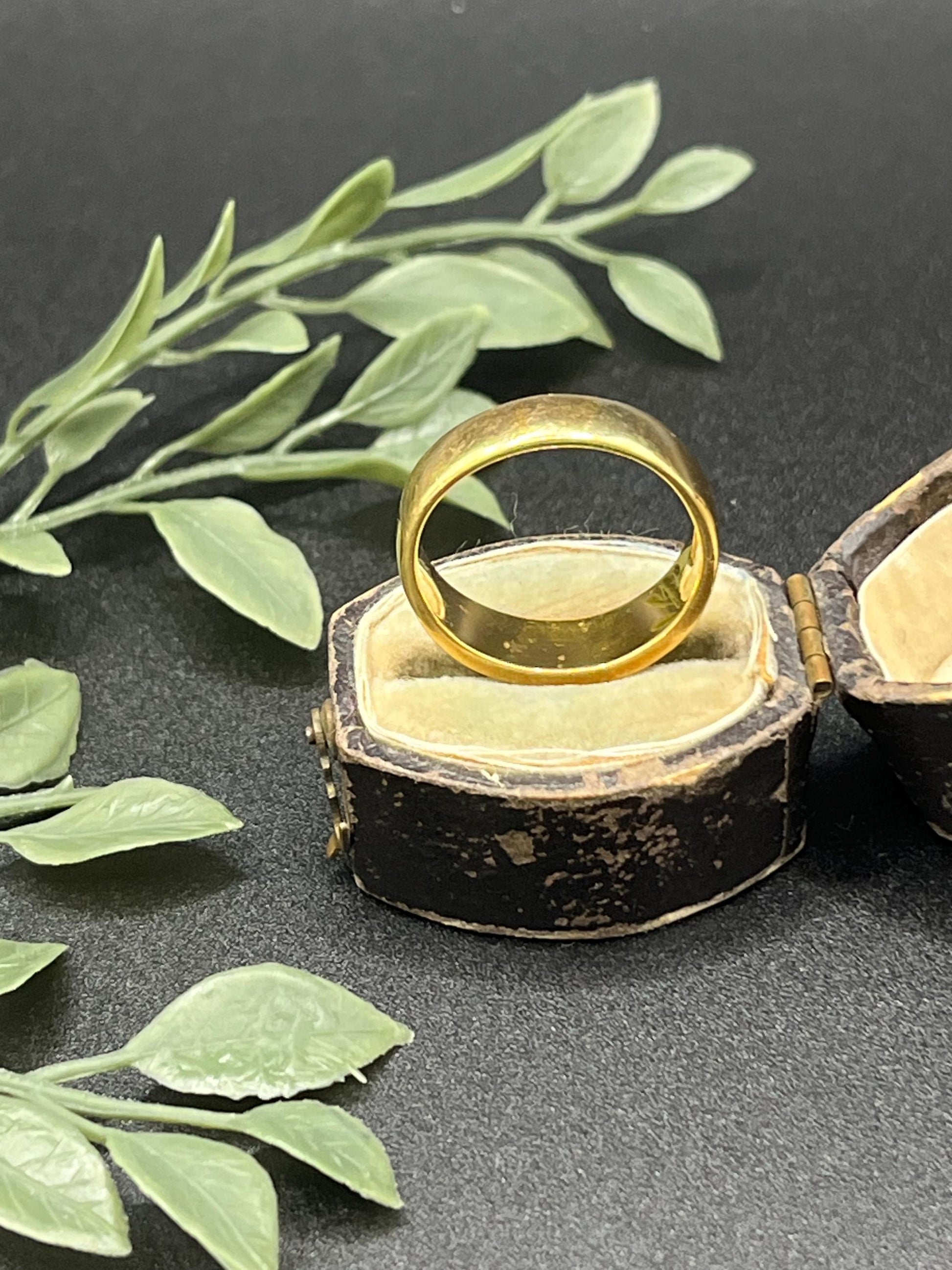 A yellow gold band ring, in a ring box
