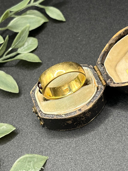 A yellow gold four stone garnet band ring, in an antique ring box