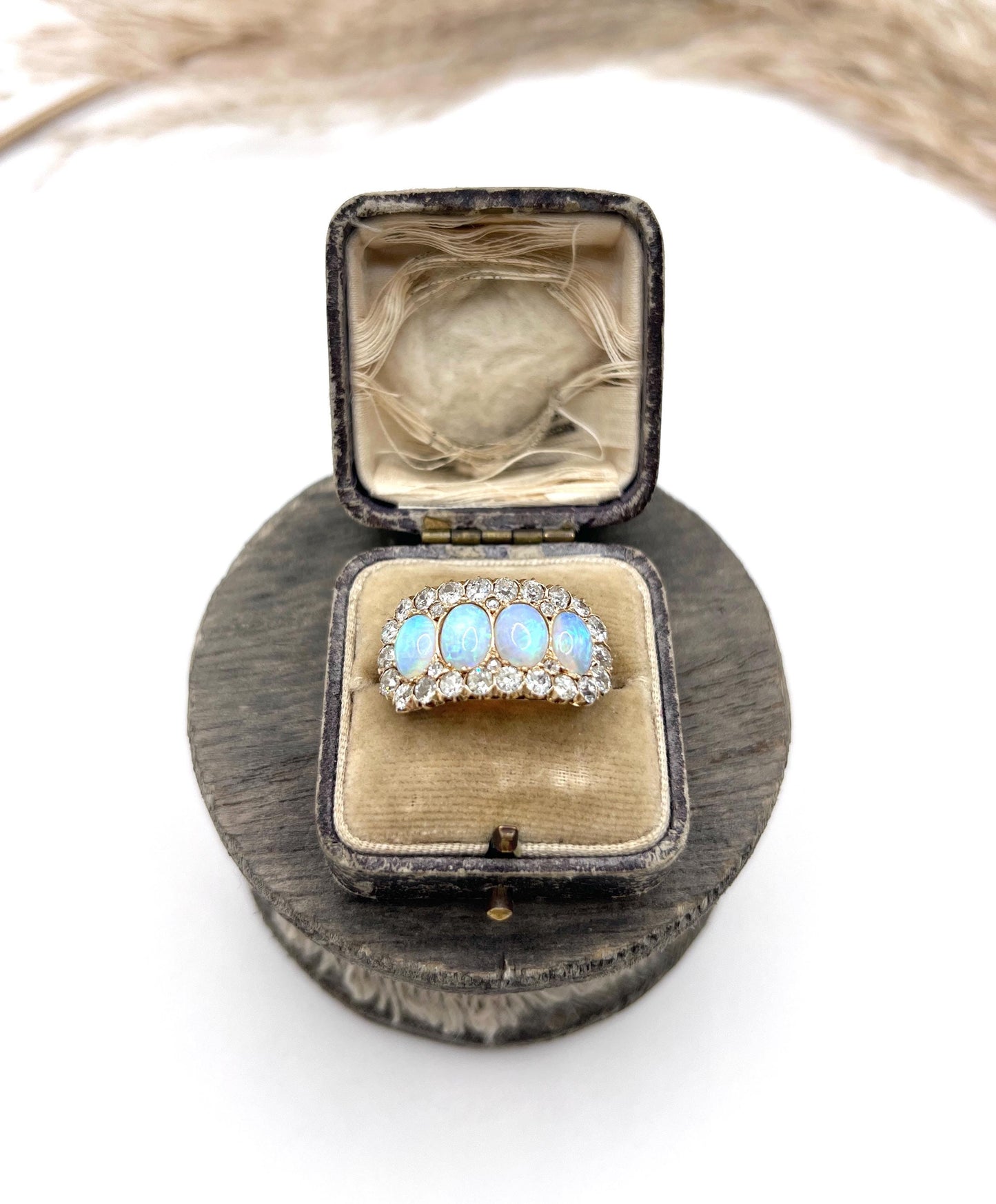 An antique oval opal and old cut diamond cluster row ring in yellow gold, in a box