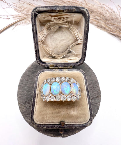 An antique oval opal and old cut diamond cluster row ring in yellow gold, in a box