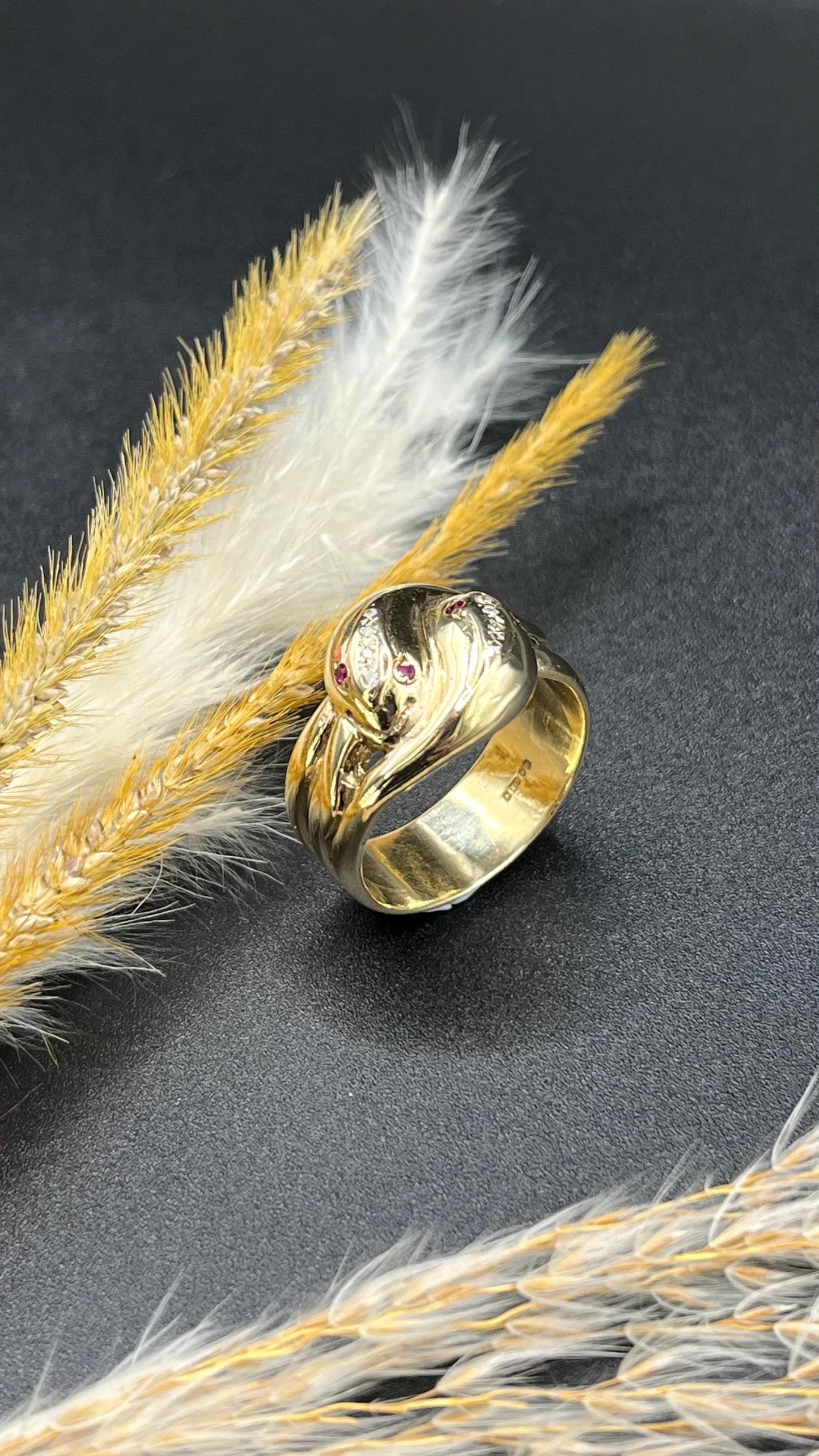A yellow gold ruby and diamond set double headed snake ring