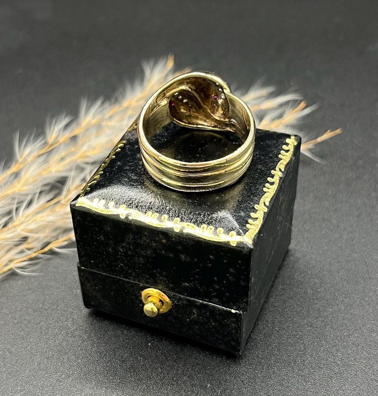 A yellow gold ruby and diamond set double headed snake ring