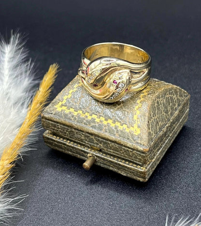A yellow gold ruby and diamond set double headed snake ring