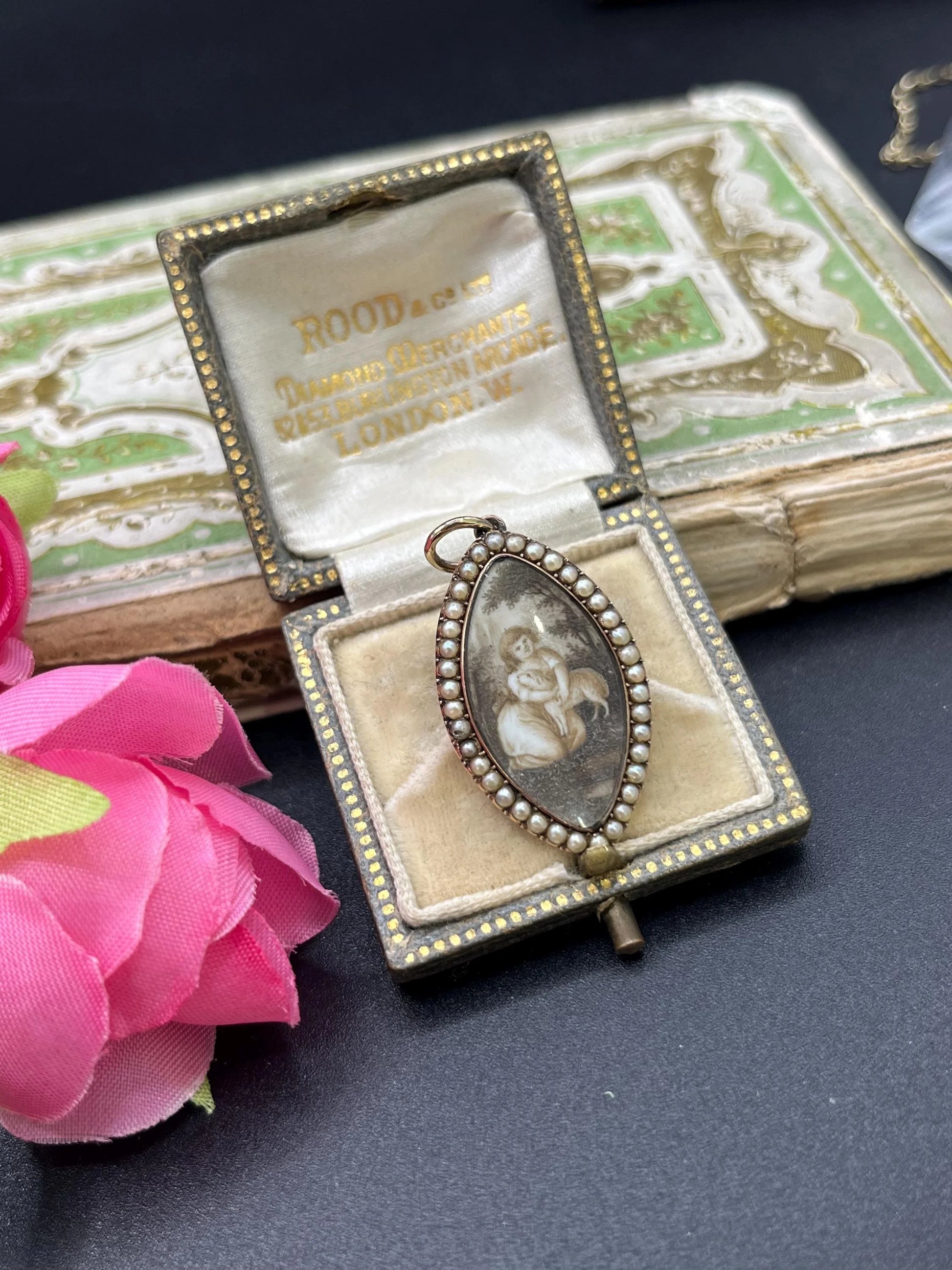 A navette shaped yellow gold seed pearl pendant with a miniature portrait, in an antique box