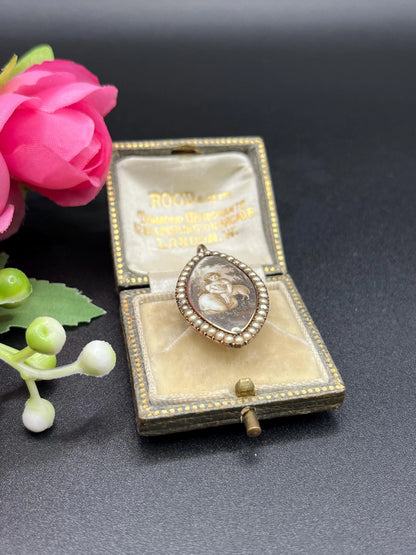 A navette shaped yellow gold seed pearl pendant with a miniature portrait, in an antique box