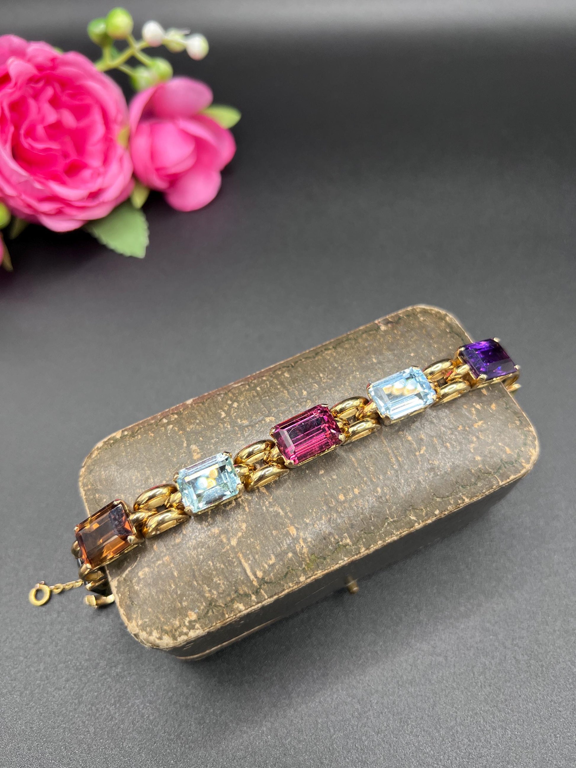 An emerald cut multi-gemstone bracelet in yellow gold