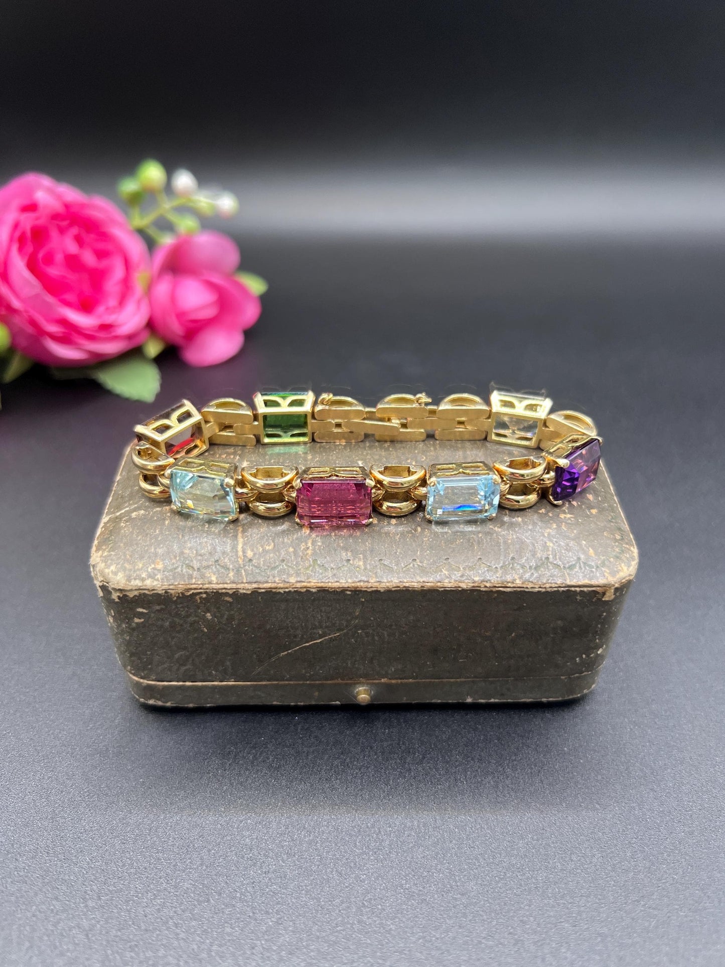 An emerald cut multi-gemstone bracelet in yellow gold