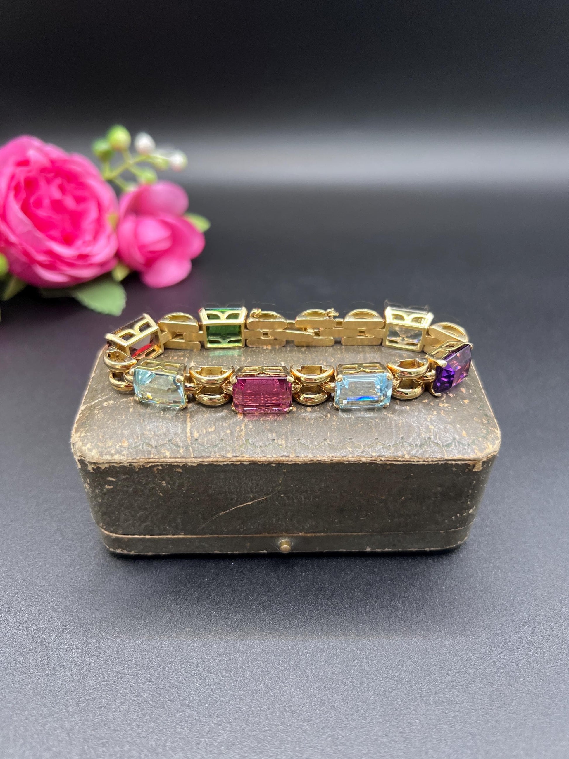 An emerald cut multi-gemstone bracelet in yellow gold