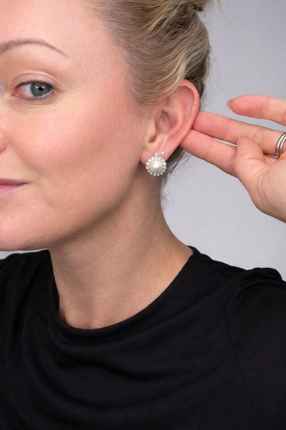 A pearl and old cut diamond floral cluster earring, modelled in an ear