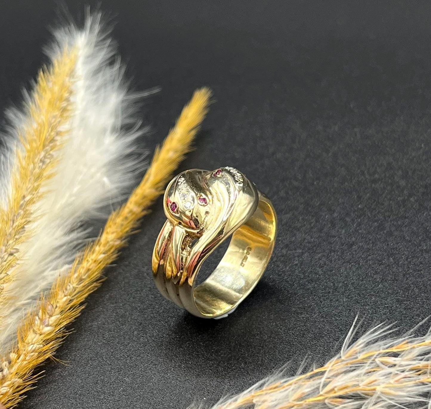 A yellow gold ruby and diamond set double headed snake ring