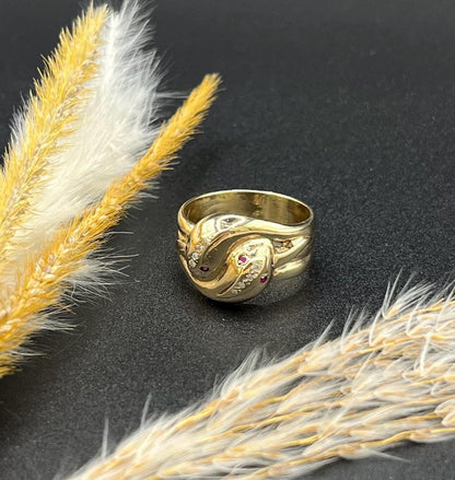 A yellow gold ruby and diamond set double headed snake ring