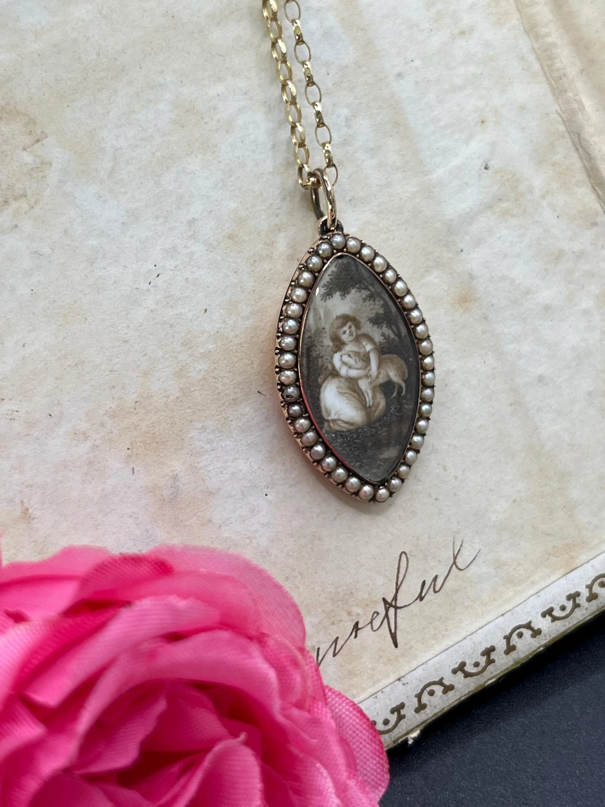 A navette shaped yellow gold seed pearl pendant with a miniature portrait, with a chain