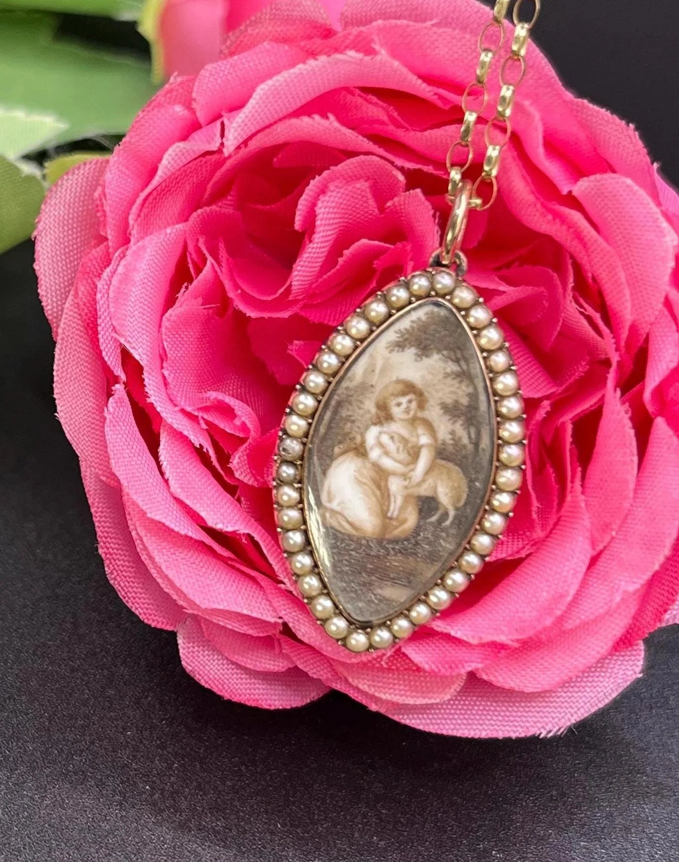 A navette shaped yellow gold seed pearl pendant with a miniature portrait, with a chain