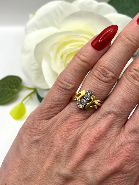 A four stone old cut diamond ring in yellow and white gold, modelled on a hand