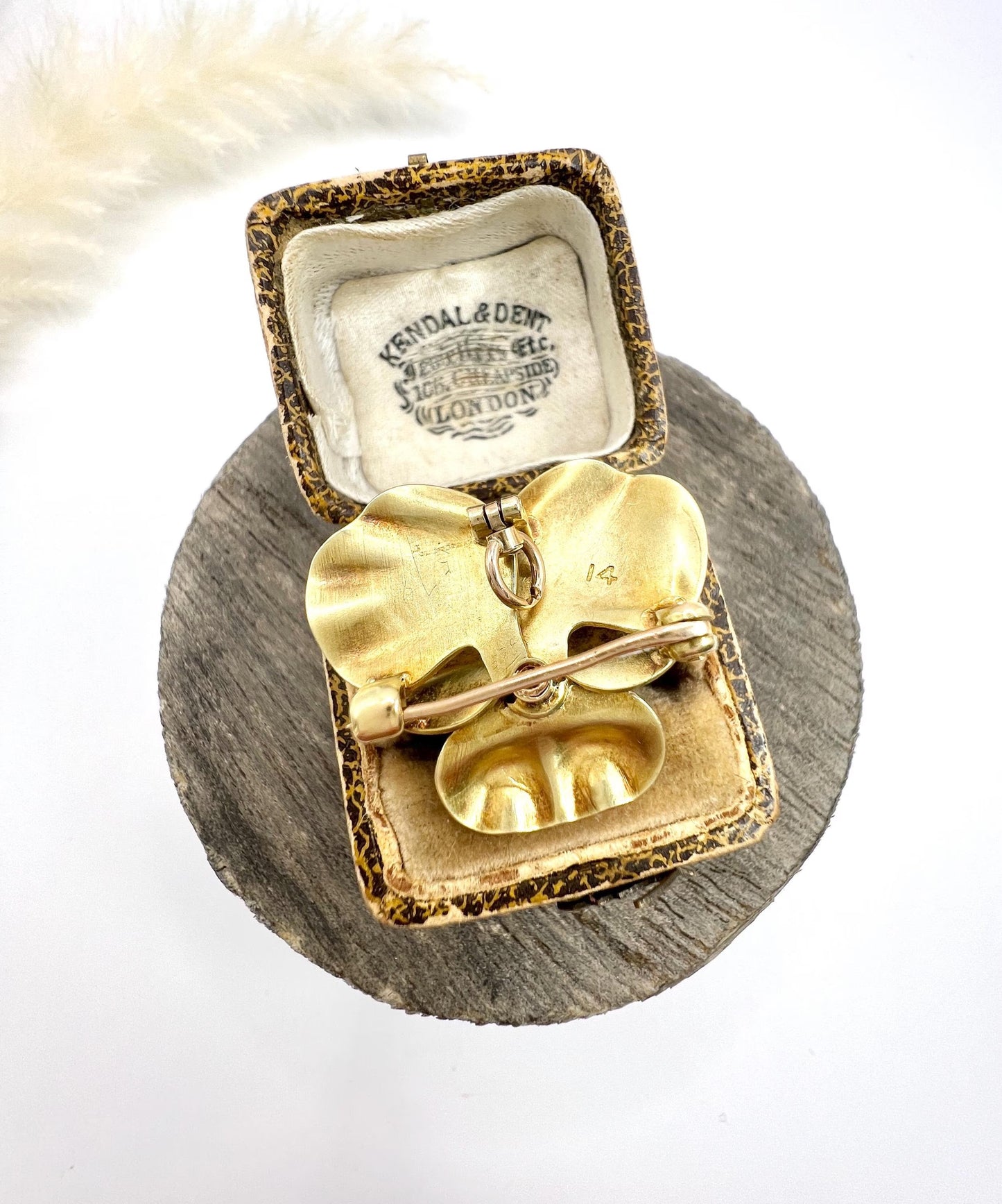An enamelled pansy flower pendant/brooch with a diamond centre, in yellow gold