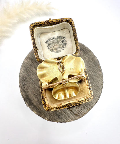 An enamelled pansy flower pendant/brooch with a diamond centre, in yellow gold