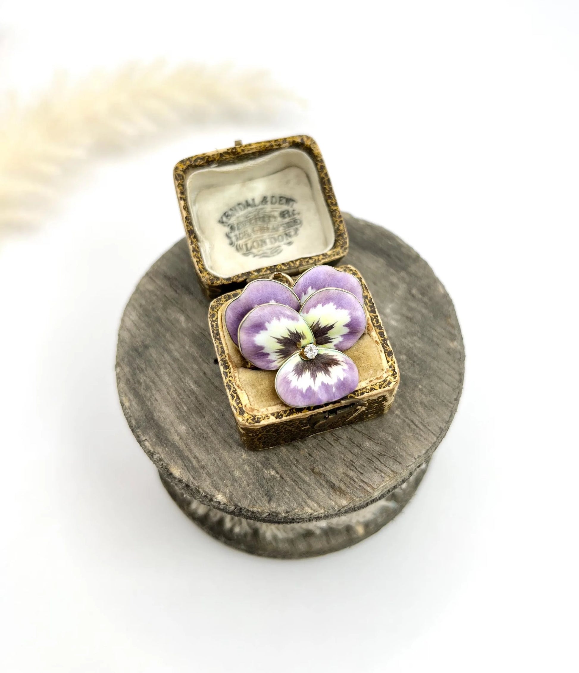 An enamelled pansy flower pendant/brooch with a diamond centre, in yellow gold