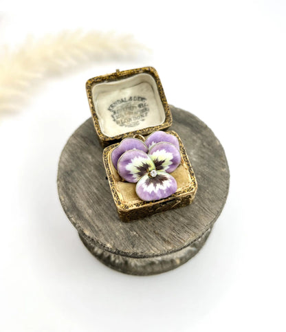 An enamelled pansy flower pendant/brooch with a diamond centre, in yellow gold