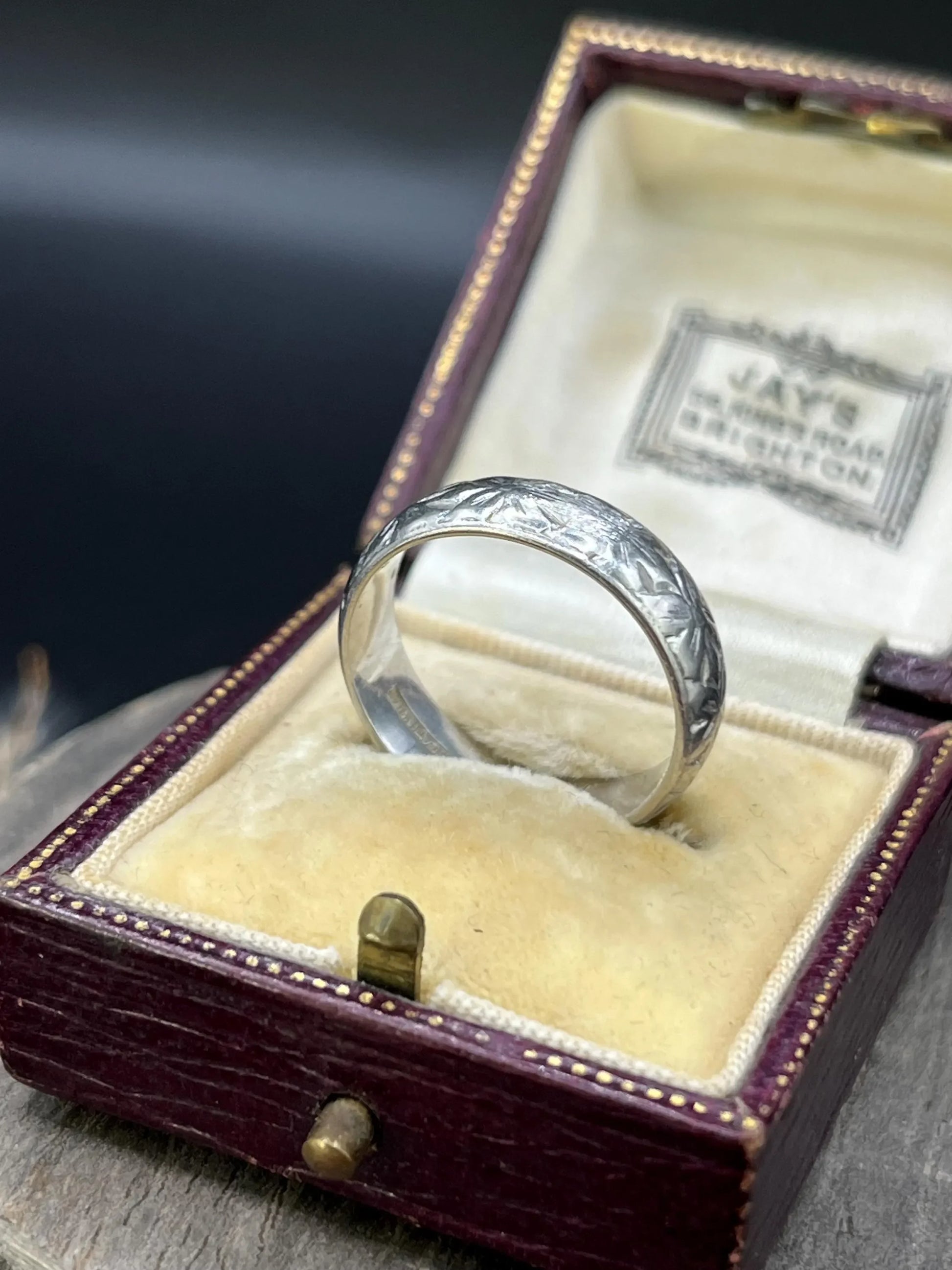 An engraved platinum wedding band ring, in an antique ring box